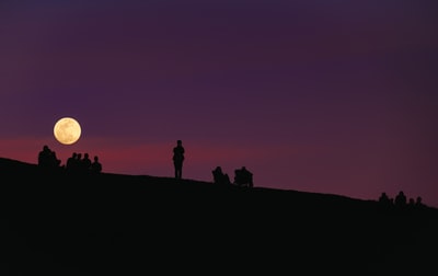 轮廓的紫色的夜空下的一群人
